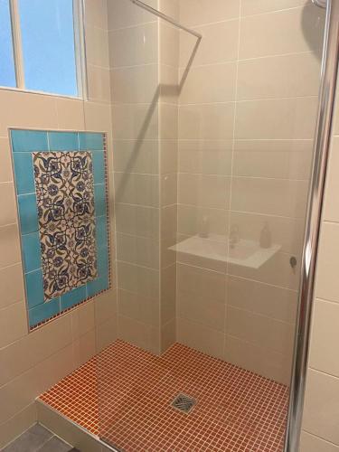 une douche avec une porte vitrée dans une salle de bain dans l'établissement Beau F3, rénové, calme, en plein centre de Nimes, à Nîmes