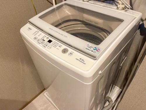 a washer and dryer sitting in a room at OPENSALE Hoco 富士吉田富士山ビューの上質な宿 駅近 本町撮影スポット徒歩1分 in Fujiyoshida
