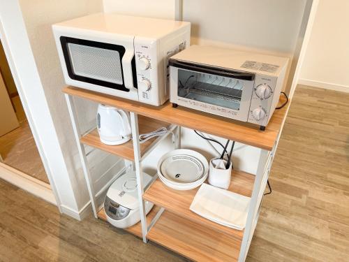 a microwave and a toaster oven on a shelf at OPENSALE Hoco 富士吉田富士山ビューの上質な宿 駅近 本町撮影スポット徒歩1分 in Fujiyoshida