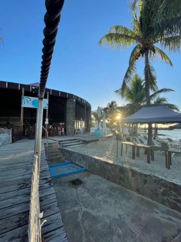 a beach with benches and umbrellas and palm trees at Studio 25 m Manganao Joela 4 personnes avec machine a laver in Saint-François