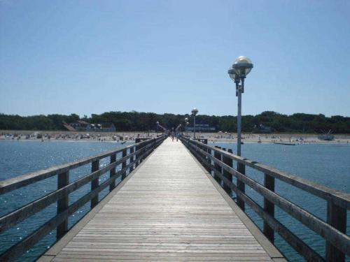 a wooden boardwalk leading to the beach with a street light at Küstenwald - Ferienwohnung Igel 67 in Müritz