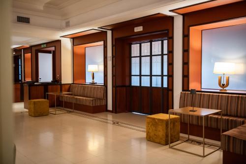 a lobby with a waiting room with benches and tables at Villa Maria Hotel & SPA in Francavilla al Mare