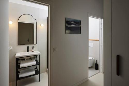 une salle de bain avec un lavabo et un miroir et des toilettes dans l'établissement Stylish Loft - 2BR and 2BA, à Paris