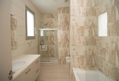a bathroom with a sink and a toilet and a shower at Seafront Villa Layla by Ruidoso Luxury in Ayia Napa