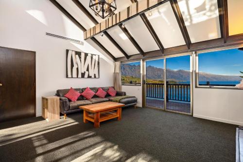 a living room with a couch and a table at Lake Views - Close to Town - Hot Tub - Spa Pool in Queenstown