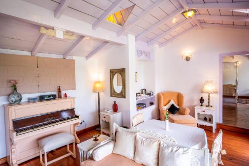 a living room with a bed and a piano at Te Aroha By Shervani in Mukteswar