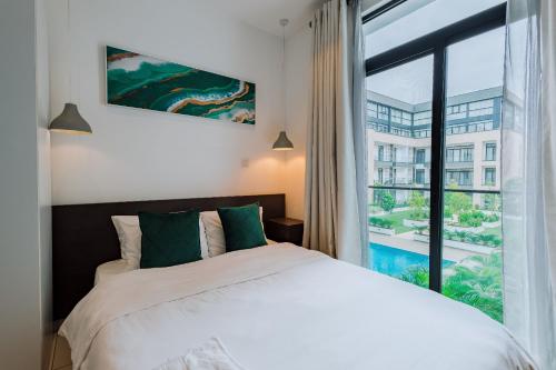 The Avery Studio at Embassy Gardens, Cantonments في آكرا: غرفة نوم بها سرير ونافذة كبيرة