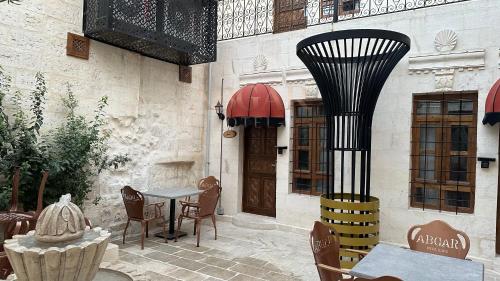 a patio with a table and chairs in front of a building at ABGAR Otel in Sanlıurfa