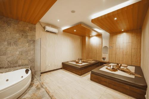 a bathroom with two sinks and a bath tub at Grand Tjokro Hotel Balikpapan in Balikpapan