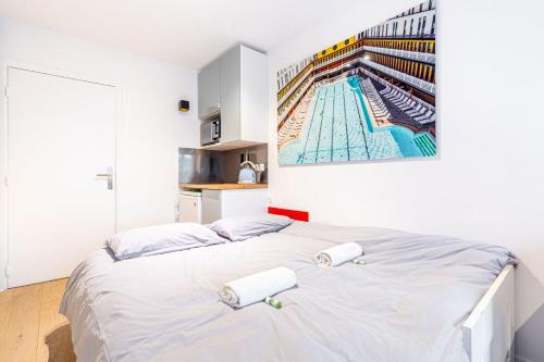 une chambre avec un grand lit blanc avec des serviettes dessus dans l'établissement Charming stay in the 16th, à Paris