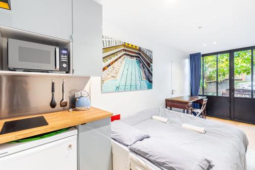 Cette petite chambre comprend un lit et un four micro-ondes. dans l'établissement Charming stay in the 16th, à Paris