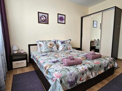 een slaapkamer met een bed met kussens en een spiegel bij La casa di Nora in Varna