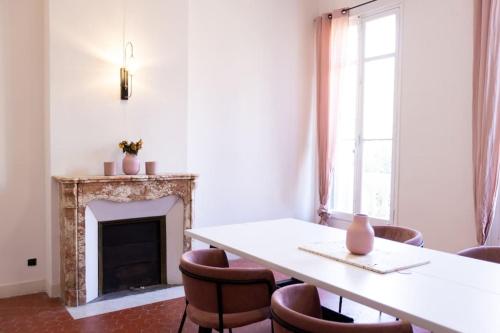 une pièce avec une table, des chaises et une cheminée dans l'établissement Grand Standing Appartement, à Marseille