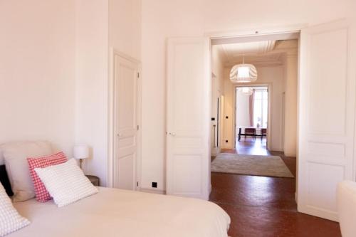 - une chambre blanche avec un lit et un couloir dans l'établissement Grand Standing Appartement, à Marseille