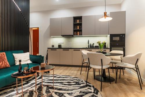 een woonkamer met een bank, een tafel en stoelen bij Frida's Dream Suite in Boedapest