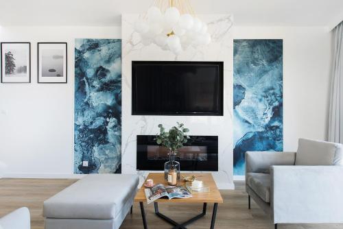 a living room with a tv and a couch and a table at Sol Marina Resort Wyspa Sobieszewska I - LoftAffair Collection in Wiślinka