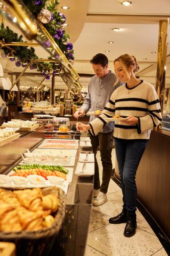 a man and a woman standing in front of a buffet at VIVA RIVERSIDE Messe Düsseldorf in Düsseldorf