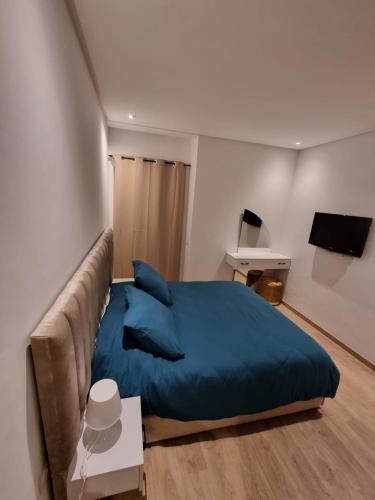 a bedroom with a blue bed and a couch at Appartement - Dar Bouazza in Dar Bouazza
