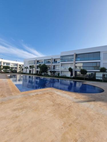an empty swimming pool in front of a building at Appartement - Dar Bouazza in Dar Bouazza