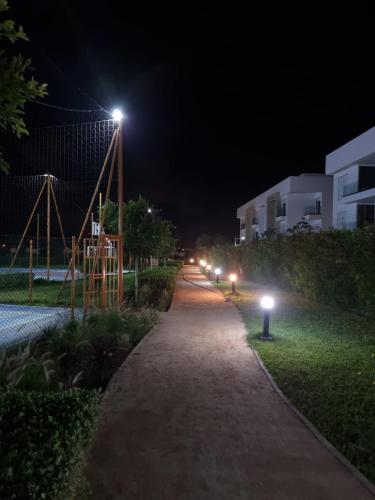 a walking path at night with lights on it at Appartement - Dar Bouazza in Dar Bouazza