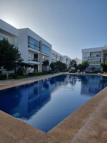 a large swimming pool in front of a building at Appartement - Dar Bouazza in Dar Bouazza
