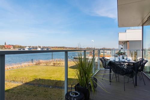 a balcony with a table and chairs and a view of the water at Sol Marina Resort Wyspa Sobieszewska I - LoftAffair Collection in Wiślinka