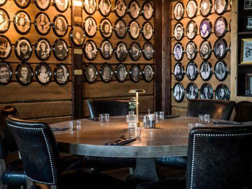 a table in a restaurant with a wall of plates at Quality Hotel Grand Royal in Narvik