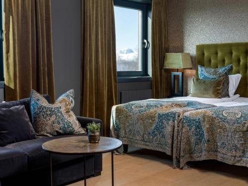 a hotel room with a bed and a couch at Quality Hotel Grand Royal in Narvik