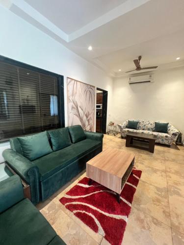 a living room with a green couch and a coffee table at Villa by the Sea in Mumbai