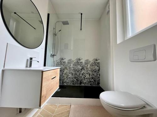 une salle de bain avec toilettes, lavabo et miroir dans l'établissement Ecrin de coton, à Rouen