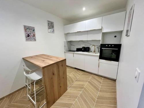 une cuisine avec des armoires blanches et un comptoir en bois dans l'établissement Ecrin de coton, à Rouen