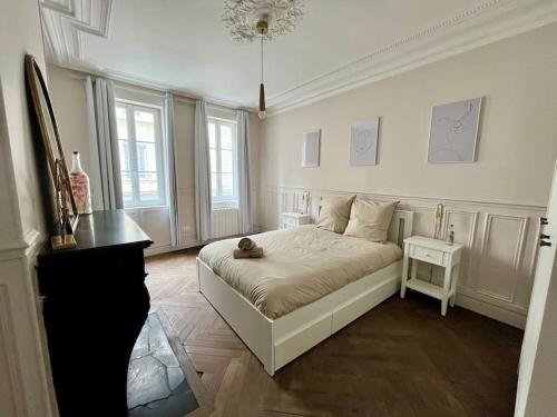 une chambre avec un lit sur lequel est assis un chat dans l'établissement Ecrin de coton, à Rouen