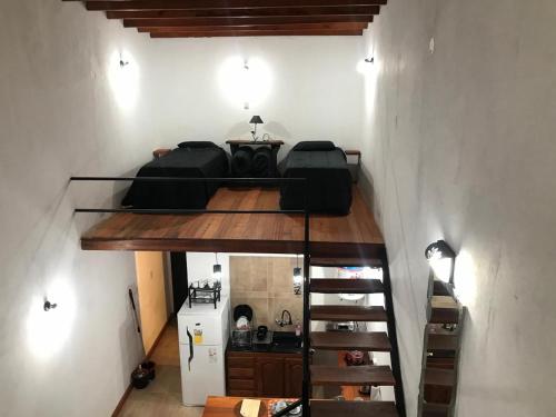 a room with two beds and a spiral staircase at Saudades del Yapeyú - Lofts in Yapeyú