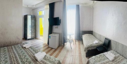 a hotel room with two beds and a table at Hotel Buta in Batumi