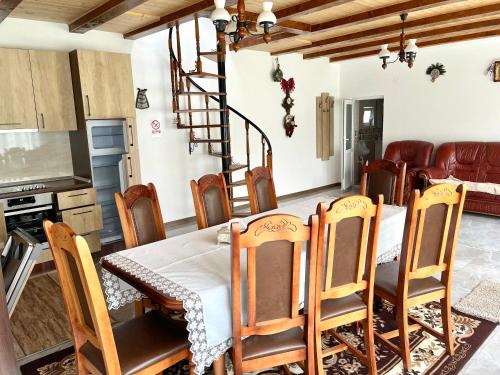a kitchen and dining room with a table and chairs at Casa de vacanță in Orlat