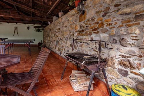 a stone wall with two chairs and a table at Maseda 1 in Villayón
