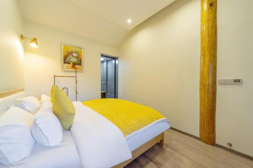 a bedroom with a white bed with white pillows at GeGeHouse - Lijiang Old Town in Lijiang