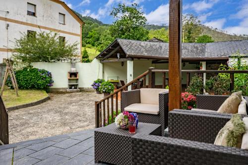 a patio with furniture and a house at Maseda 1 in Villayón