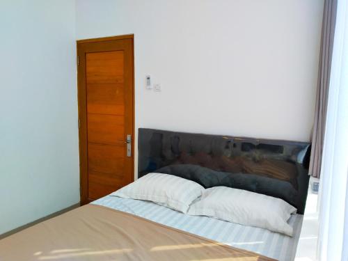 a bed with two pillows on it in a room at Themas Guest House in Jakarta