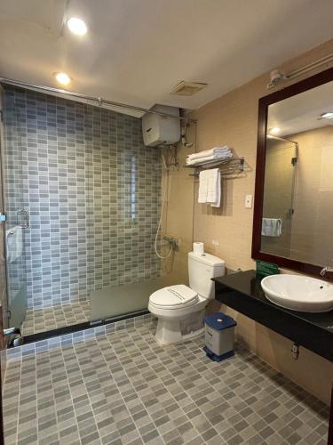 a bathroom with a toilet and a sink and a mirror at Kim Tho Hotel in Can Tho