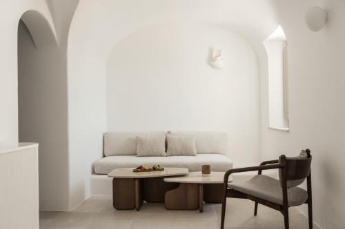 salon z kanapą, stołem i krzesłem w obiekcie Canaves Ena - Small Luxury Hotels of the World w mieście Oia