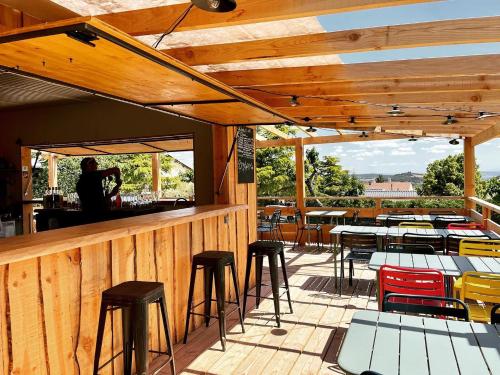 une terrasse avec tables et tabourets dans un restaurant dans l'établissement Eco Lodge, terrasse, piscine, Parc du Pilat, à Saint-Appolinard