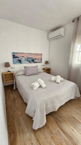 a bedroom with a large bed with two towels on it at Apartamento Los Mosaicos in Santiponce
