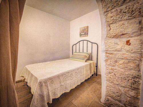 a bedroom with a bed in a stone wall at Trullo Originale di Alberobello in Alberobello