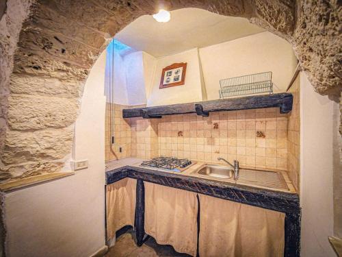 a kitchen with a sink and a stone wall at Trullo Originale di Alberobello in Alberobello