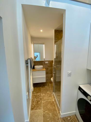 une salle de bain avec un lavabo, des toilettes et un miroir dans l'établissement Chaleureux et Lumineux studio Centre Historique Nimes, à Nîmes