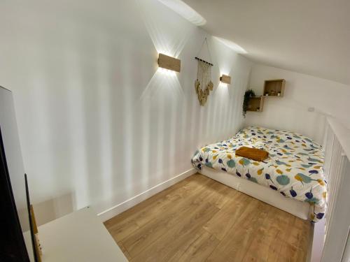 - une petite chambre avec un lit et du parquet dans l'établissement Chaleureux et Lumineux studio Centre Historique Nimes, à Nîmes