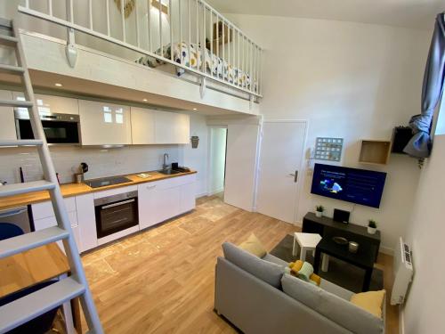 un salon avec un canapé et une cuisine dans l'établissement Chaleureux et Lumineux studio Centre Historique Nimes, à Nîmes