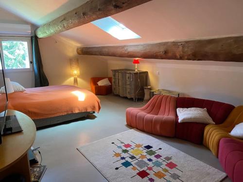 - une chambre avec un lit et un canapé rouge dans l'établissement Le Mas Carradou , Mas de Prestige en campagne, à Monteux
