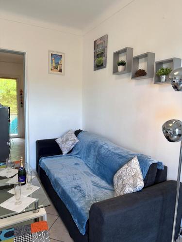 - un canapé dans le salon avec une couverture bleue dans l'établissement Appartement dans villa roi soleil, à Antibes
